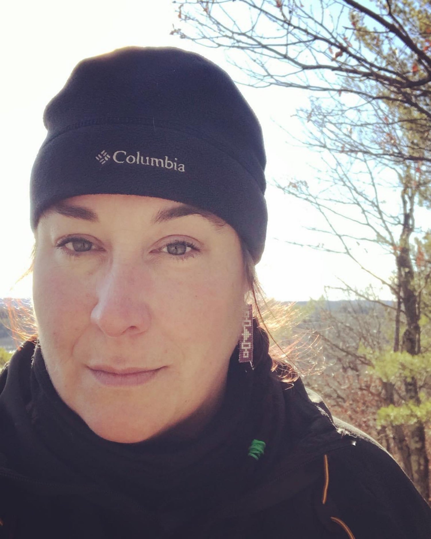 Photo image of Terrain UL owner Tina Eckerlin, wearing hat outside in sunshine.